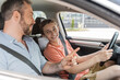 © LIGHTFIELD STUDIOS - happy teenaged boy sitting next to dad while learning how to drive car.