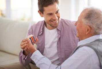 Canvas Print - From generation to generation. a senior father giving his son a medal.