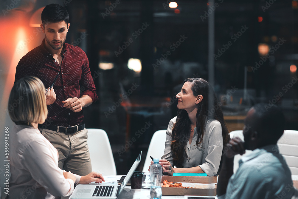 The whole team is on board for the night shift. colleagues having a meeting during a late night in a modern office.