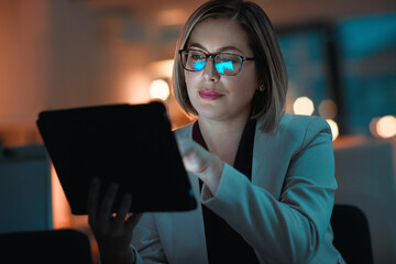 Poster - Making smart night time business moves. a businesswoman using a digital tablet during a late night at work.