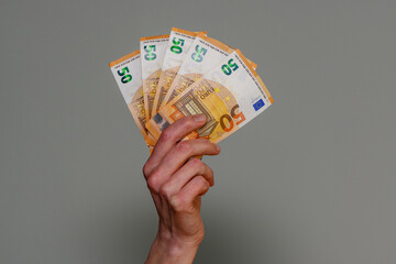 banknotes of 50 euros in a female hand on the background 2