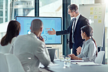 Poster - using visual aid is always a plus. a businessman delivering a presentation in the boardroom.