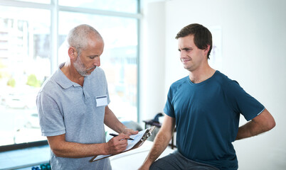 Sticker - Still having pain in your back. a handsome mature male physiotherapist having a consultation with a patient.