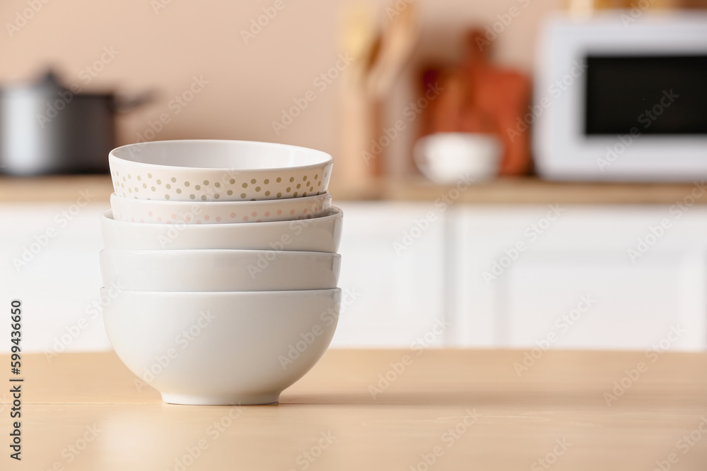 Set of stacked bowls on wooden table in kitchen