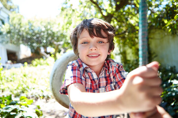 Poster - Kids make the world awesome. a young boy swinging in the yard.