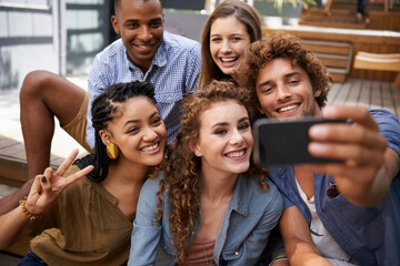 Capturing their moments of friendship. a group of friends taking a self-portrait on a cameraphone.