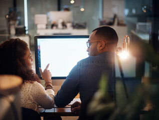 Aufkleber - Working on their plans for success throughout the day and night. Rearview shot of two businesspeople working together on a computer in an office at night.