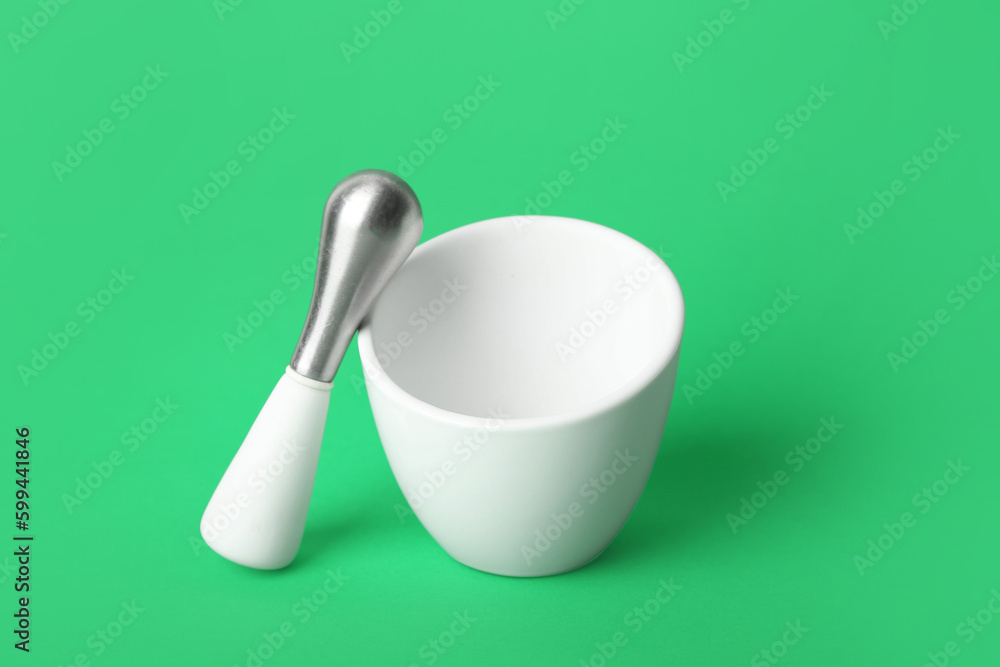 Mortar and pestle on green background