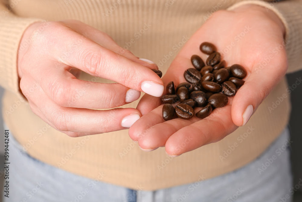 Woman holding coffee beans, closeup