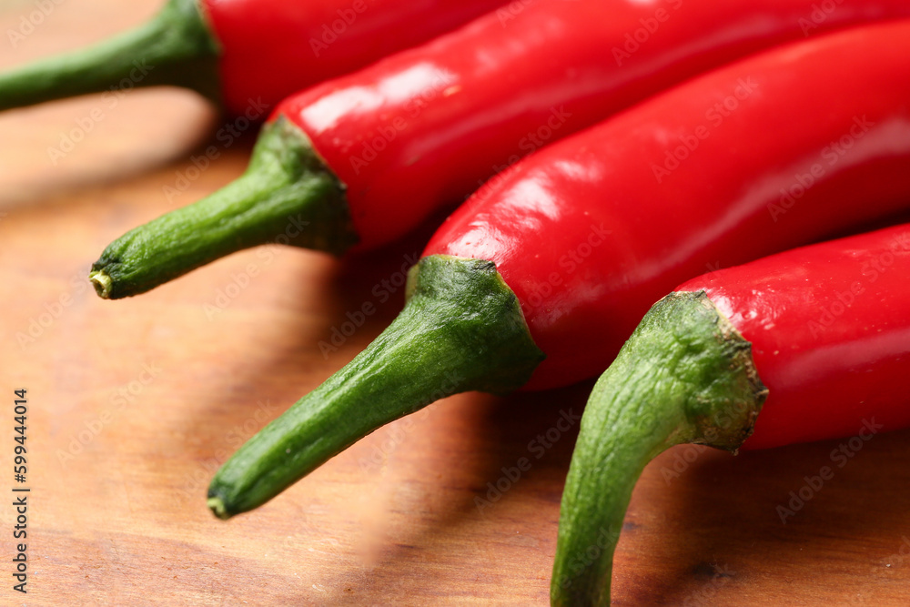 Fresh hot chili peppers on brown wooden background