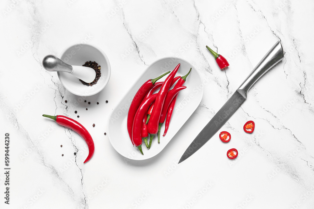 Plate with fresh chili peppers on white marble background
