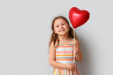 Poster - Little girl with heart shaped balloon on light background. Children's Day celebration