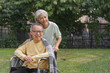 © Pichsakul - Senior woman pushing wheelchair of disabled husband to walking and relaxing with happiness in park