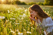 © VICHIZH - portrait of a beautiful, happy woman in a chamomile field, smelling flowers and enjoying nature