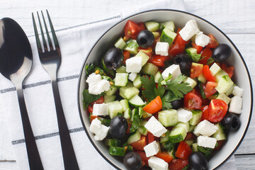 Wall Mural - Turkish Shepherds Salad  is a delicious dish made with fresh vegetables like bell pepper, cucumber and tomato and cheese closeup in the bowl on the wooden table. Horizontal top view from above