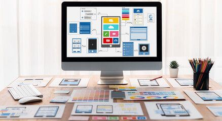 Digital and paper wireframe designs for web or mobile app UI UX display on laptop computer screen. Panoramic shot of developer workspace for brainstorming and design application framework. Scrutinize