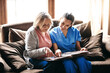 © Nikish H/peopleimages.com - Bringing history alive. a nurse and a senior woman looking at a photo album together.