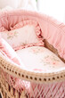 Beautiful pink floral bedding for a baby girl in a bassinet in nursery room. Generative AI