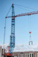 Wall Mural - Crane lifting a building module to its position in the structure. Construction site of an residential building