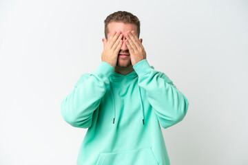 Wall Mural - Young handsome caucasian man isolated on white background covering eyes by hands