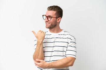 Wall Mural - Young handsome caucasian man isolated on white background pointing to the side to present a product