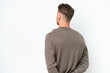 © luismolinero - Young blonde caucasian man isolated on white background in back position and looking back
