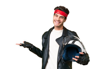 Young caucasian man with a motorcycle helmet over isolated background extending hands to the side for inviting to come