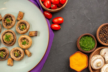 Wall Mural - top view cooked mushrooms inside plate with seasonings on dark background dish mushrooms dinner cooking meal