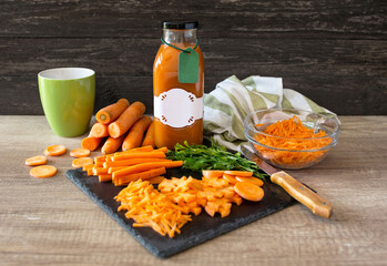 Wall Mural - healthy and raw carrot and carrot juice on a wooden table.