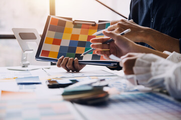 Close up ux developer and ui designer brainstorming about mobile app interface wireframe design on table with customer breif and color code at modern office.Creative digital development agency