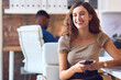 © Monkey Business - Young Smiling Businesswoman Working At Desk In Office Messaging On Mobile Phone