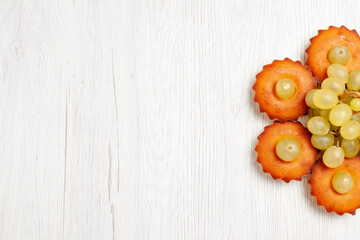 top view yummy little cakes lined with grapes on white desk cake pie sweet dessert tea cookie