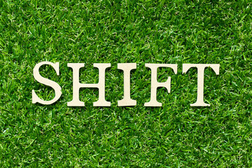 Sticker - Wood letter in word shift on green grass background