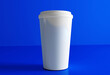 © adobedesigner - Small paper coffee cup with lid isolated on blue background, front view. Takeaway coffee package mock up. 3d rendering.