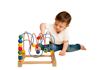 Toddler baby is playing logic educational games on a studio isolated on a white background. Happy child play with educational toy, learning logic. Kid aged one year four months