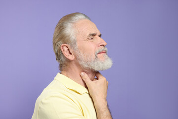 Wall Mural - Senior man suffering from sore throat on light purple background. Cold symptoms