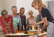 © Cameron Mcdonald/peopleimages.com - Food, senior cooking class and a woman teaching people in the kitchen of a home for meal preparation. Pasta maker, equipment and learning with mature friends watching a female chef follow a recipe