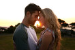 © Anne B/peopleimages.com - Sunset, love or couple in nature on romantic holiday vacation for bonding or relaxing on date together. Forehead, travel or people hug or embrace in summer with romance or peace in park in the dark