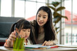 © Art_Photo - Portrait happy love asian family mother teach daughter asian girl learn, study on table, student, kid, child.Mom and young girl writing with book and pencil lessons in homeschool at home.Education
