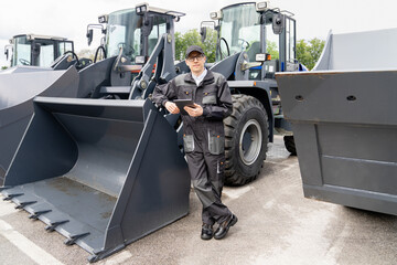 Poster - Serviceman with digital tablet on a background of the tractor