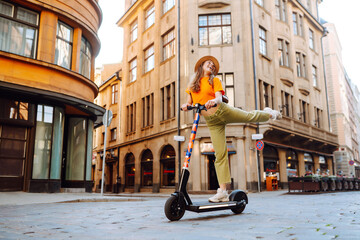 Young woman driving electric scooter through the city. Active life. Ecological transportation concept.