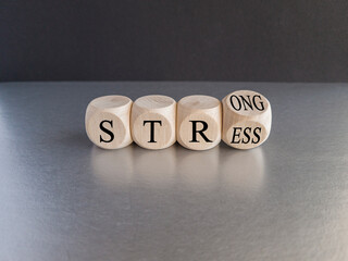 Strong stress symbol.Turned wooden cubes with words 'strong stress'. Beautiful gray table, black background, copy space. Business and strong stress concept.