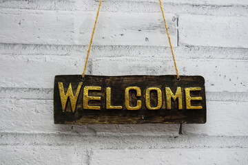 Poster - Welcome sign hanging with rope on white brick wall background