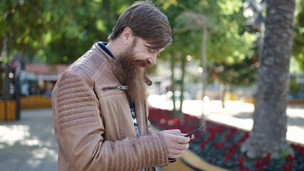 Canvas Print - Young redhead man smiling confident using smartphone at park