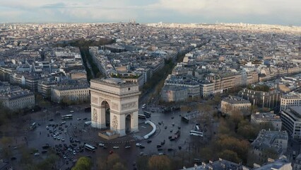 Wall Mural - Flying backwards above Arc de Triumph monument and Paris building rooftops, France, Late afternoon light