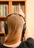 Fototapeta  - Kobieta z blond włosami z słuchawkami na uszach stojącą przy płytach cd