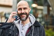 © Krakenimages.com - Young bald man smiling confident talking on the smartphone at street