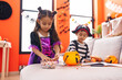 © Krakenimages.com - Adorable boy and girl having halloween party holding candies at home