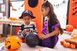 © Krakenimages.com - Adorable boy and girl having halloween party drawing on balloon at home