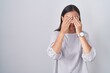 Young hispanic woman standing over white background rubbing eyes for fatigue and headache, sleepy and tired expression. vision problem